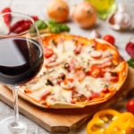Glass-of-red-wine-with-pizza-on-cutting-board