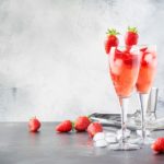 Rossini-alcoholic-cocktail-with-Italian-sparkling-wine-strawberry-puree-and-ice-in-champagne-glasses-place-for-text-selective-focus