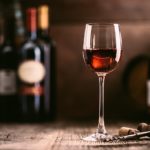 Wine-tasting-experience-in-the-rustic-cellar-and-wine-bar-red-wine-glass-and-collection-of-excellent-wines-on-the-background