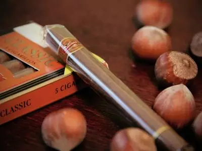 Cigar in wrapper with package and nuts around it