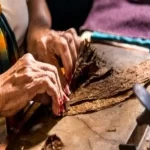 A person hand rolling cigars