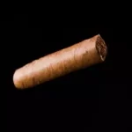 A cigar sitting against black background