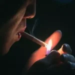 Person lighting a cigar