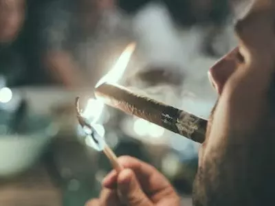 Someone lighting a cigar using a match