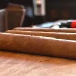 Three cigars laying next to each other on a table